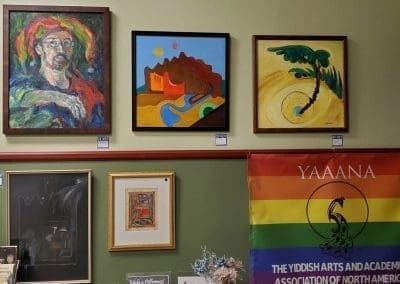 a wall of paintings and a flag